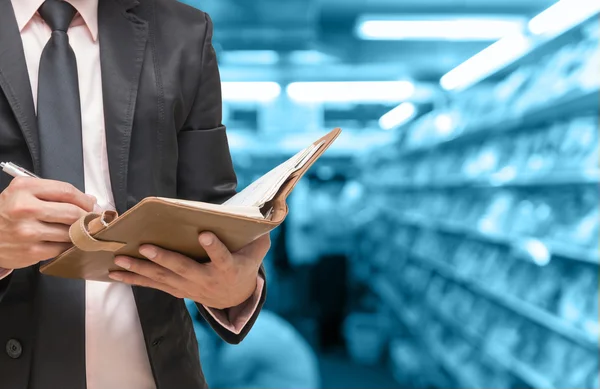 Schrijven van het boek van de opmerking op Abstract zakenman wazig foto van boekhandel met mensen achtergrond, blauwe kleur achtergrond — Stockfoto