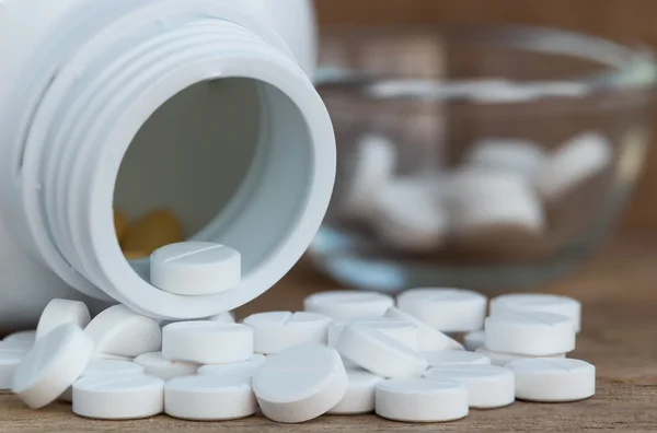 Tabletták, orvosságos-üvegek fa háttér — Stock Fotó