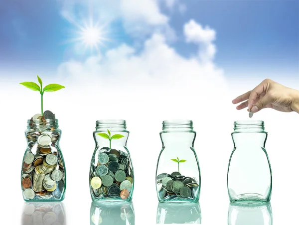 Кран положить смешанные монеты и семена в прозрачную бутылку на белом фоне, Концепция роста инвестиций в бизнес — стоковое фото