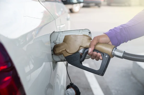 Hand hold Fuel nozzle to add fuel in car at filling station — Stock Photo, Image