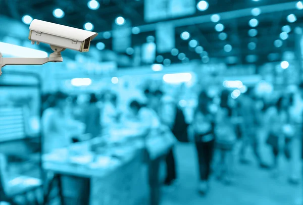 Câmera de segurança CCTV no monitor do centro comercial com pessoas no abstrato desfocado foto fundo, tom de cor azul — Fotografia de Stock
