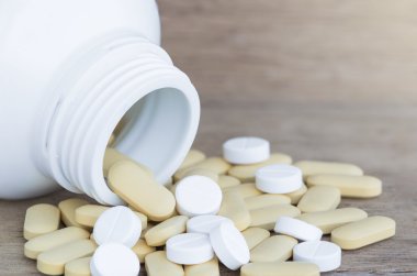 Birçok hap ve vitamin ahşap zemin üzerine tıp şişelerde