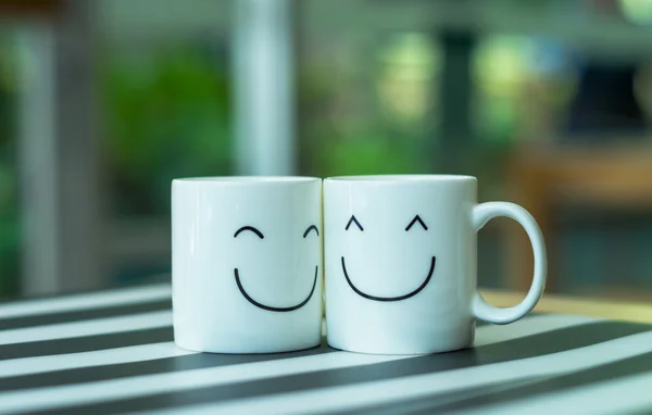 Duas xícaras felizes na mesa, sobre o conceito de amor — Fotografia de Stock