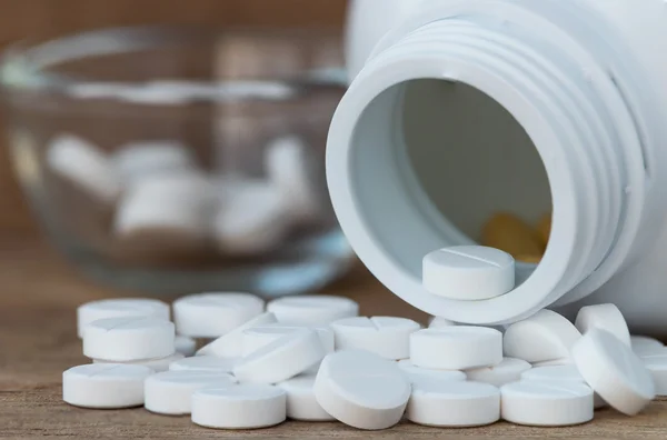 Píldoras en botellas de medicina sobre fondo de madera — Foto de Stock