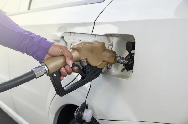 Hand halten Tankdüse, um Kraftstoff im Auto an der Tankstelle hinzuzufügen — Stockfoto