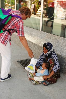 Dilenci kadın gıda bebeği için kadına verir