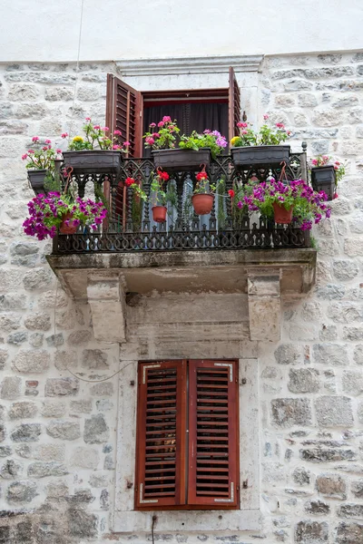 Vecchio balcone con fiori e finestra con persiane Immagini Stock Royalty Free
