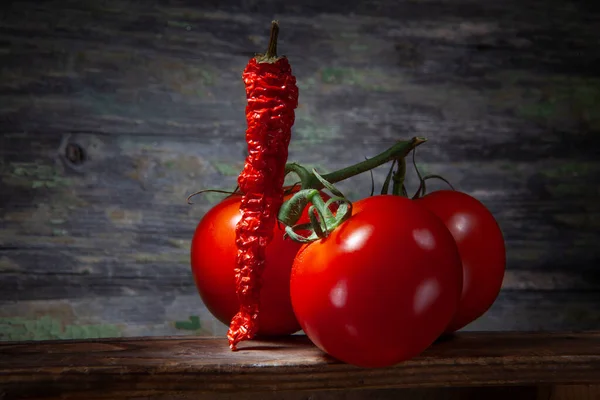 Pimienta Roja Picante Triturada Con Tres Tomates Sobre Fondo Madera —  Fotos de Stock