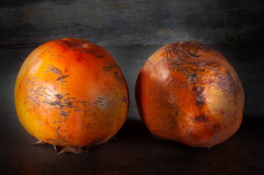 İki tane çok olgun ve tatlı hurma meyvesi. Olgunlaşmanın son aşaması. Yumuşak, lezzetli ve çok tatlı.