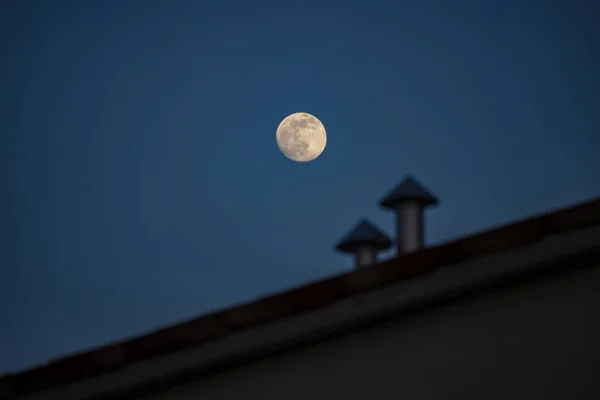 Фото Shinny Moon Blurred Roof Two Metal Chimneys — стоковое фото