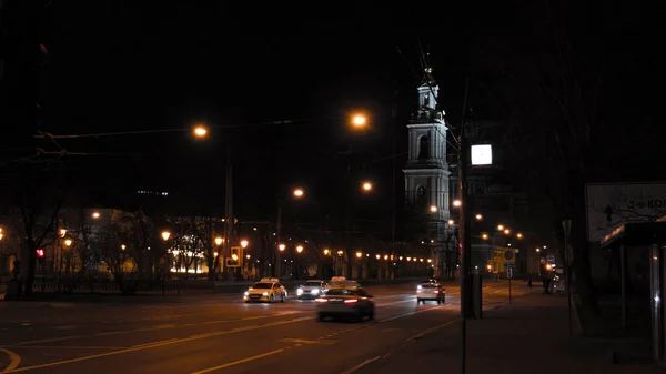 Widok Nocny Drogi Miejskiej Samochodami Niej Dzwonnica Kościoła Tle — Zdjęcie stockowe