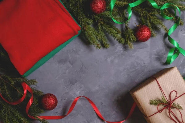 El yapımı hediye kutusu brunchlar, koniler, toplar, kurdeleler ve koyu arkaplanda kırmızı ve yeşil örülü süveterler ile süslenmiş. Mutlu noel tebrik kartları. Düz yatıyordu. Boşluğu kopyala