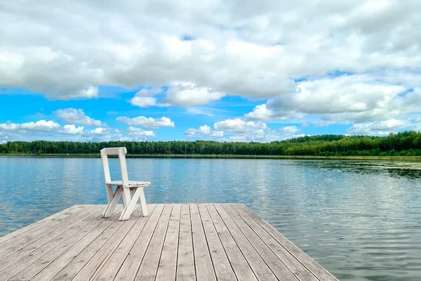 White empty deck chair at the lake dock. — Stock Photo, Image