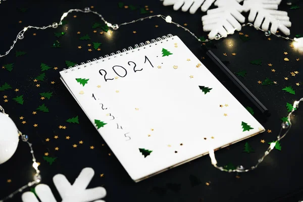 Lista de resoluções de Ano Novo em um notebook em fundo verde escuro. — Fotografia de Stock