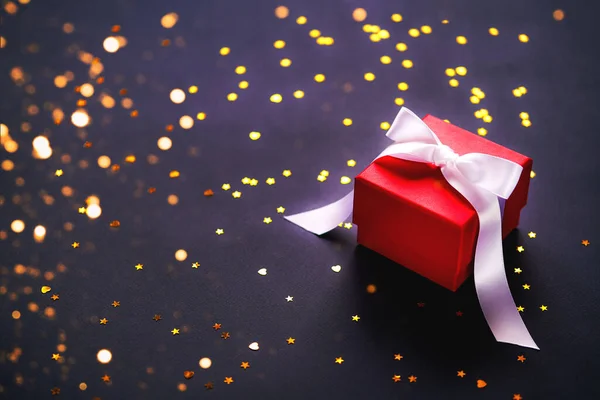Caixa de presente vermelho com fita branca, fundo dourado brilhante — Fotografia de Stock