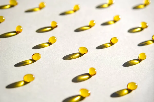 Yellow gel transparent gel capsules of vitamin d or omega 3 in spoon.