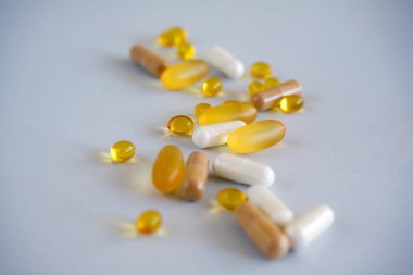Yellow gel transparent gel nutraceutical capsules of vitamin d or omega 3 in spoon. clipart