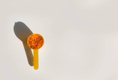 Sarı jel şeffaf fındıklı D vitamini kapsülleri veya kaşıkta omega 3..