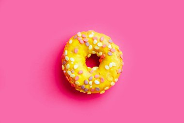 Renkli mor arka planda sarı şekerli donut.