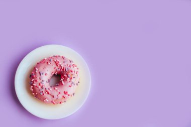 Renkli mor arka planda pembe şekerli donut..