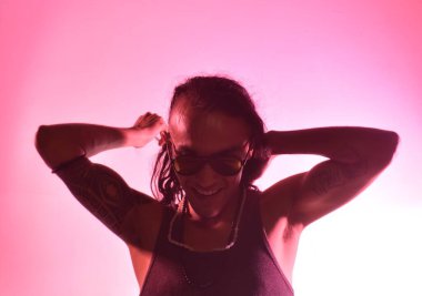 Pembe romantik arka planda gülümseyen ve flört eden çekici, uzun saçlı adamın ifadesi.