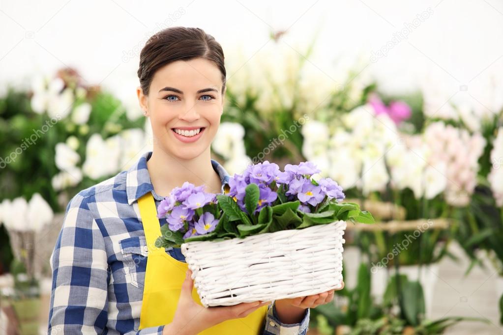 florist woman smiling with white wicker basket flowers