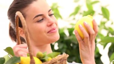 gülümseyen kadın bir limon alır ve sepeti hasır koydu