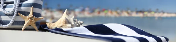 Sac sur la plage avec étoile de mer, coquille et serviette — Photo
