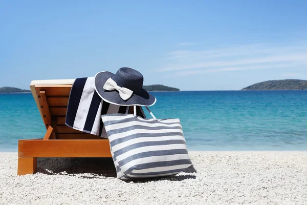 Transat avec sac, chapeau bleu et serviette sur la plage — Photo