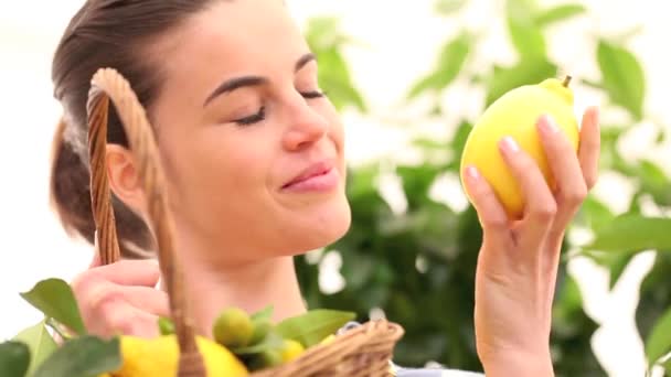 Wanita tersenyum memilih lemon dan memasukkannya ke dalam keranjang wicker — Stok Video