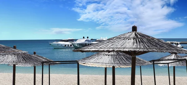 Yacht amarré sur la plage avec parasols — Photo