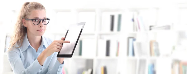 Frau mit Tablet in der Hand zeigt mit Finger auf Bildschirm — Stockfoto