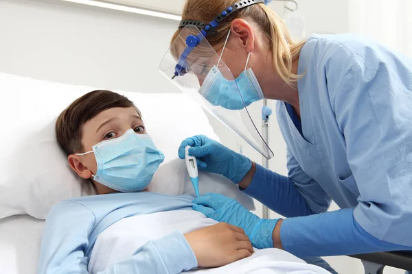 Медсестра Термометром Измеряет Температуру Больного Ребенка Больничной Койке Носит Защитный — стоковое фото