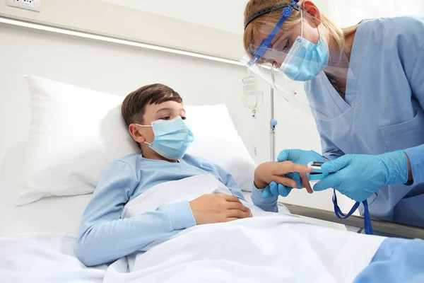 Enfermera Con Oxímetro Pulso Niño Paciente Cama Hospital Con Máscara —  Fotos de Stock