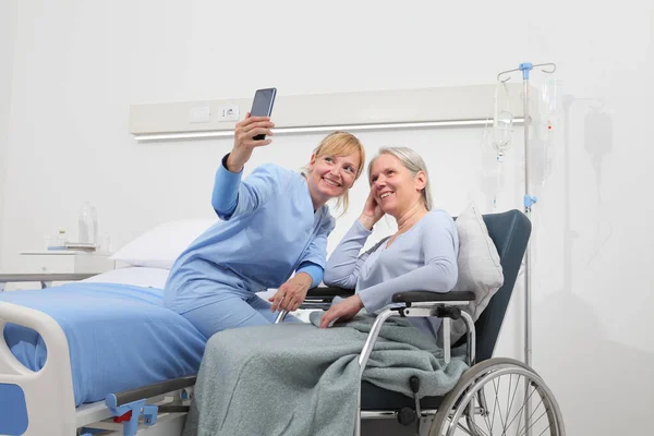 Sjuksköterska Hjälper Med Mobiltelefon För Att Kontakta Den Äldre Damens — Stockfoto