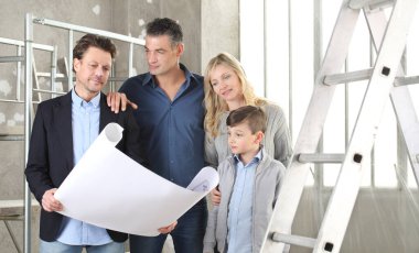 Mimar, çocuklu bir aileye ev tasarımı planlarını gösteriyor. Ev görünümü, iç dekorasyon ve ev düzeni hakkında konuşmak için iç inşaat sahasında buluşacağız.