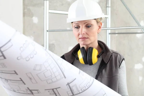 Bauarbeiterin Schaut Sich Bauplan Trägt Helm Und Gehörschutz Kopfhörer Auf — Stockfoto