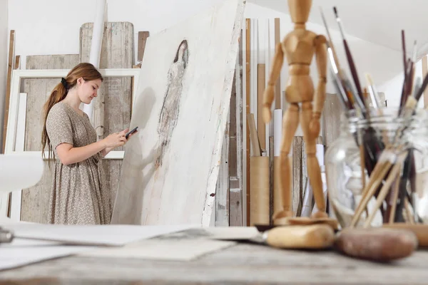 Foto Interior Una Joven Artista Pie Frente Lienzo Usando Teléfono —  Fotos de Stock