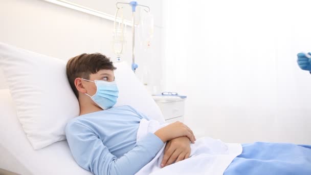 病院のベッドの子供 熱の温度を測定する看護師 保護マスクを身に着けている コロナウイルスは19保護コンセプトをCovid — ストック動画