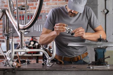 Garaj atölyesindeki antika bisikleti tamir et. Teçhizat tezgahında. Aletlerle.