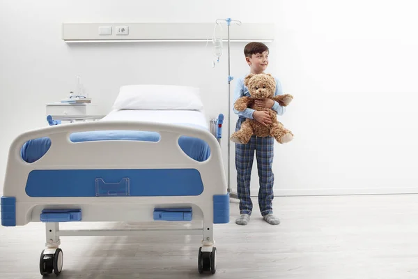 Boldog Gyermek Kórházi Szobában Áll Ágy Mellett Egy Plüssmackó Visel — Stock Fotó