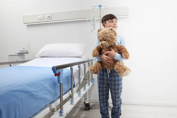 Child Hospital Room Standing Next Bed Hugging Teddy Bear Wearing — Stock Photo, Image