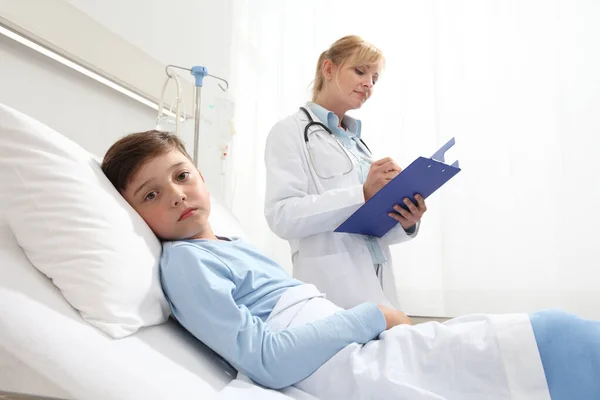 Sick Child Lying Bed Hospital Room Looking Camera Doctor Him — Stockfoto