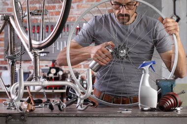 Garaj atölyesindeki antika bisikleti tamir et. Teçhizat tezgahında. Aletlerle.