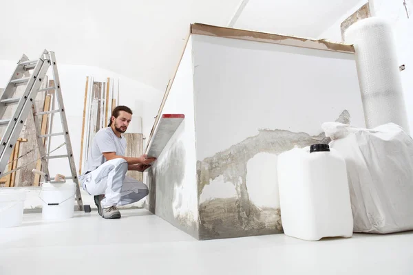 Bauarbeiter Stuckateur Schaut Auf Die Wasserwaage Und Überprüft Die Wand — Stockfoto