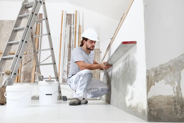 Bouwvakker Stukadoor Man Kijkt Naar Waterpas Controleert Muur Bouwplaats Van — Stockfoto