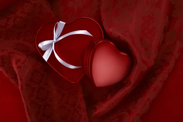 情人节 红心形状闪亮的金属包装与缎带弓隔离在锦缎织物上 适用于贺卡贺卡 — 图库照片
