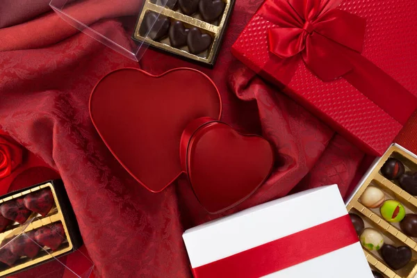 情人节背景 礼品盒的组成巧克力和红心金属盒 与蝴蝶结和缎带 顶部看锦缎面料 适用于贺卡或糕点海报模板 — 图库照片