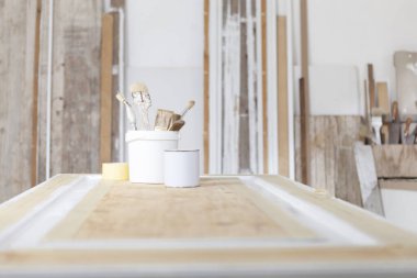 Ahşap kapılar üzerinde ahşap atölye, boya fırçaları ve renkli teneke kutular, ahşap duvarlarda izole edilmiş arka plan fotokopi alanı, ahşap el sanatları, iç mimar, restorasyon, diy ve el yapımı iş konsepti