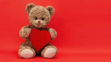 Hediye kartı, kırmızı arka planda kalbi olan oyuncak ayı.